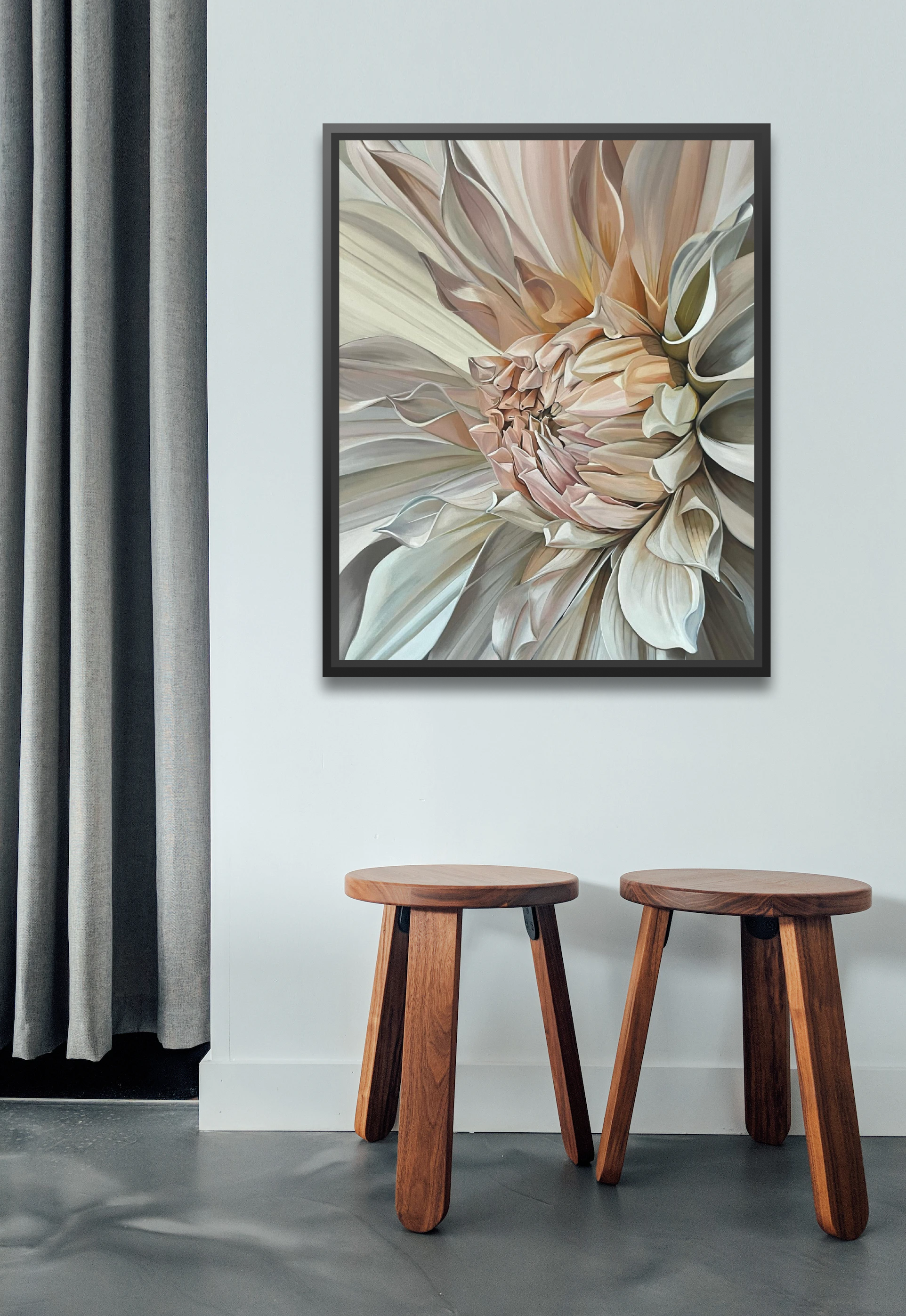 Framed floral artwork on a wall above two wooden stools.